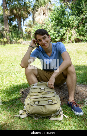 Jungen Latino mit Rucksack und Handy Stockfoto