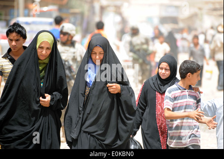 Irakische Frauen gehen auf einen belebten Markt Straße im östlichen Bagdad, Irak, Juni 21. US-Soldaten der Alpha Company, 2. Bataillon, 5 Stockfoto