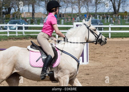 Teenager-Mädchen reiten ihr Palomino Pferd Pony im Sprung Ring bei einem lokalen Horse Show. Stockfoto