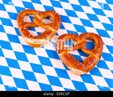 Zwei Brezel in Herzform auf weißen blauen Hintergrund, Ansicht von oben Stockfoto