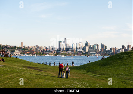 Familien und Freunde versammeln sich am Gas Works Park mit Blick auf Lake Union und die Skyline von Seattle. Stockfoto