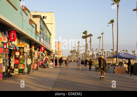 Käufer Fuß und ein junger Mann skateboards auf dem sonnigen Venice Beach Boardwalk in Los Angeles, Kalifornien. Stockfoto