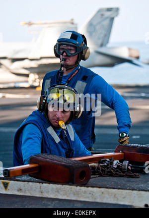 Luftfahrt Boatswain Mate (Handling) Airman Adam Insley Manöver einen MH-60 s Sea Hawk-Hubschrauber, die der Eightballers zugewiesen Stockfoto