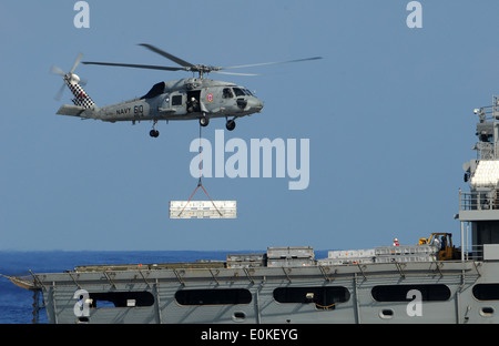 Ein SH-60F Sea Hawk, die "Black Knights" des Hubschraubers Anti-Submarine Squadron 4 zugewiesen liefert eine Last von Kampfmitteln, die Stockfoto