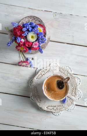 Blumen-Gänseblümchen und Tasse Kaffee Stockfoto