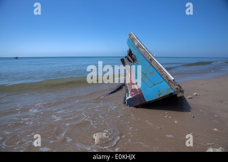 alten Longtail-Boot Zusammenstoß am Strand Stockfoto