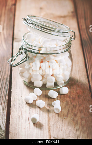 Süße Marshmallow in einem Glas auf einem Holztisch Stockfoto