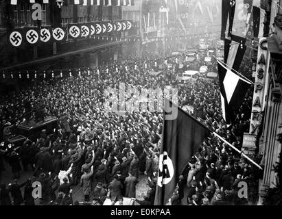 Publikum begrüßt Nazi-Führer Adolf Hitler in den Straßen von München Stockfoto