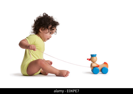 Kleinkind Mädchen spielen mit Spielzeug Ente auf weißem Hintergrund Stockfoto