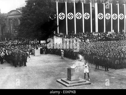 Ein deutscher Leichtathlet Beleuchtung die Fackel bei der Eröffnungsfeier der Olympischen Spiele 1936 in Berlin. Stockfoto