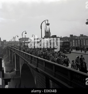 1950er Jahren Geschichtsbild, Busse Schlange als große Zahl von Menschen über Blackfriars Bridge Fuß. London, England. Stockfoto