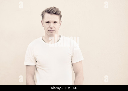 Porträt des jungen Mannes vor Wand. Nachdenklichen Ausdruck und Blick in die Kamera. Stockfoto