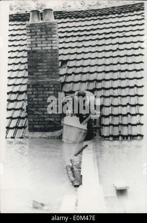 12. Juni 1953 - Überschwemmungen in Südwestfrankreich - Fluss Doubs überläuft: ein Bewohner von einem überfluteten Haus in Montbeliard-Bereich auf dem Dach thront entfernt seine Habseligkeiten. Stockfoto