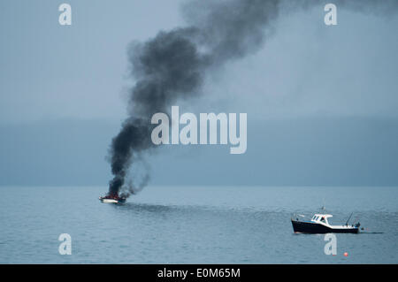 Aberystwyth Wales UK, Freitag, 16. Mai 2014 kleines Motorboot in Flammen an der Cardigan Bay direkt vor dem Strand bei Aberystwyth an der Westküste von Wales. Augenzeugen sagen, dass der Besitzer des Bootes versucht, die Flammen zu löschen, bevor Sie gerettet durch das lokale RNLI inshore Rettungsboot Credit: Keith Morris/Alamy Live-Nachrichten Stockfoto