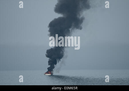 Aberystwyth Wales UK, Freitag, 16. Mai 2014 kleines Motorboot in Flammen an der Cardigan Bay direkt vor dem Strand bei Aberystwyth an der Westküste von Wales. Augenzeugen sagen, dass der Besitzer des Bootes versucht, die Flammen zu löschen, bevor Sie gerettet durch das lokale RNLI inshore Rettungsboot Credit: Keith Morris/Alamy Live-Nachrichten Stockfoto