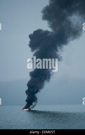 Aberystwyth Wales UK, Freitag, 16. Mai 2014 kleines Motorboot in Flammen an der Cardigan Bay direkt vor dem Strand bei Aberystwyth an der Westküste von Wales. Augenzeugen sagen, dass der Besitzer des Bootes versucht, die Flammen zu löschen, bevor Sie gerettet durch das lokale RNLI inshore Rettungsboot Credit: Keith Morris/Alamy Live-Nachrichten Stockfoto