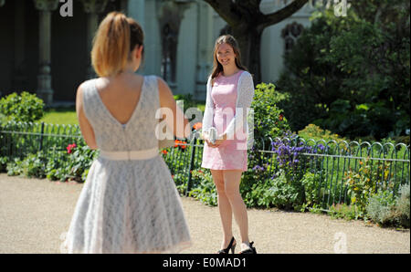 Brighton, Sussex UK 16. Mai 2014 - zwei junge Frauen die heiße Sonne genießen in Brighton Pavilion Gardens heute auf ihrem Weg zu einer Hochzeit mit Temperaturen um 23 ° c zu erreichen, die das gute Wetter am Wochenende Foto von Simon Dack/Alamy Live News voraussichtlich dauern wird erwartet Stockfoto