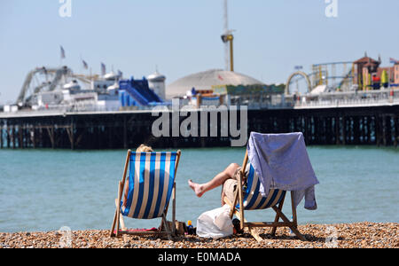 Brighton, Sussex UK 16. Mai 2014 - Personen genießen Sie die Sonne auf Liegestühlen am Strand von Brighton Stockfoto