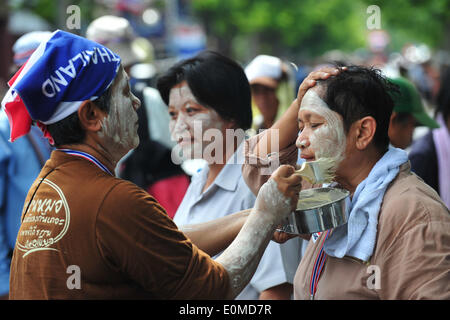 Bangkok, Thailand. 16. Mai 2014. Ein Thai Anti-Regierungs-Demonstranten setzt Pulver auf die andere Fläche, um Schutz vor starker Sonneneinstrahlung während einer Kundgebung vor dem Parlamentsgebäude als Senatoren Debatte um Lösungen für politische Konflikt des Landes in Bangkok, Thailand, 16. Mai 2014 finden. Bildnachweis: Rachen Sageamsak/Xinhua/Alamy Live-Nachrichten Stockfoto