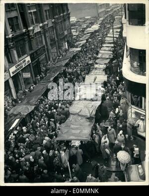 12. Dezember 1955 - trotzen große Menschenmengen den Regen für ihre Weihnachtseinkäufe IN der PETTICOAT LANE. Mit dem shopping Tage bis Weihnachten strömten wächst weniger große Menschenmengen, Petticoat Lane, London Open-Air-Markt am Sonntagmorgen, trotz des Regens heute Morgen. Foto zeigt: Die Szene in Middlesex Street heute Morgen, als Massen von Käufern gesucht Weihnachten Verhandlungen trotz des Regens. Fast jede erdenkliche Ware ist auf den Verkauf in diesem Markt. Stockfoto