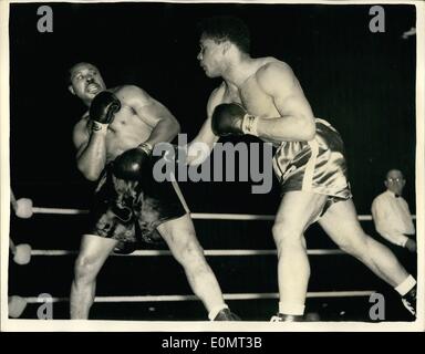 6. Juni 1956 - Archie Moore behält Titel im Halbschwergewicht. gegen Yolande Pompey bei Haringay: Archie Moore der Champion im Halbschwergewicht der Welt, behielt seinen Titel, nachdem er Yolande Pompey in der zehnten Runde ihrer Contest heute Abend besiegt hatte. Der Ringrichter stoppte den Wettbewerb um Pompeius vor weitere Strafe zu bewahren. Foto zeigt Pompey am Moore (auf der linken Seite) rechts in die fünfte Runde ihrer Contest schwingt. Stockfoto