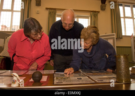 Ältere Frau (rechts) erklären ihre Großväter Weltkrieg Erinnerungsstücke an die Besucher einer Ausstellung... Stockfoto