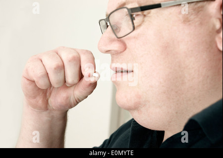 Mann, die Einnahme von Atorvastatin Tabletten (Statine) Stockfoto