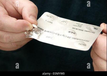 Mann, die Einnahme von Atorvastatin Tabletten (Statine) Stockfoto