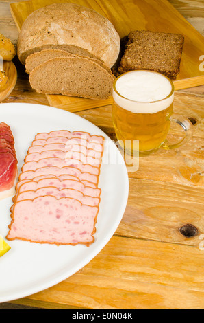 Wurst, eingelegtes Gemüse, Vollkornbrot und Bier, eine traditionelle deutsche kalte Mahlzeit Stockfoto