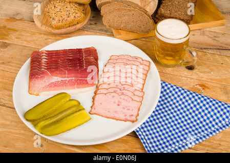 Wurst, eingelegtes Gemüse, Vollkornbrot und Bier, eine traditionelle deutsche kalte Mahlzeit Stockfoto