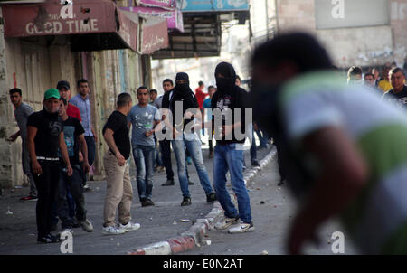 Hebron, Westjordanland, Palästinensische Gebiete. 16. Mai 2014. Palästinensische Demonstranten mit Steinen werfen auf israelische Truppen während der Auseinandersetzungen nach einer Kundgebung zur Solidarität mit den palästinensischen Gefangenen in israelischen Gefängnissen, in der West Bank von Hebron 16. Mai 2014 statt. Rund 120 Palästinenser ohne Gerichtsverfahren in Israel inhaftiert wurden auf einen unbefristeten Hungerstreik, Essen nur Salz und Trinkwasser, für die letzten 23 Tage fordern ein Ende der so genannten '' Verwaltungshaft © Mamoun Wazwaz/APA Images/ZUMAPRESS.com/Alamy Live News Stockfoto