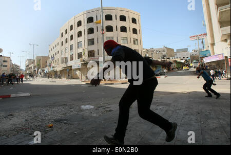 Hebron, Westjordanland, Palästinensische Gebiete. 16. Mai 2014. Palästinensische Demonstranten mit Steinen werfen auf israelische Truppen während der Auseinandersetzungen nach einer Kundgebung zur Solidarität mit den palästinensischen Gefangenen in israelischen Gefängnissen, in der West Bank von Hebron 16. Mai 2014 statt. Rund 120 Palästinenser ohne Gerichtsverfahren in Israel inhaftiert wurden auf einen unbefristeten Hungerstreik, Essen nur Salz und Trinkwasser, für die letzten 23 Tage fordern ein Ende der so genannten '' Verwaltungshaft © Mamoun Wazwaz/APA Images/ZUMAPRESS.com/Alamy Live News Stockfoto