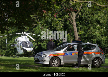 Trafen sich Polizei und MD902 Explorer Hubschrauber von der Kent, Surrey & Sussex Air Ambulance Trust vor Ort in Ruskin Park nach Notfall Flug nach Kings College Hospital in Südlondon. Stockfoto