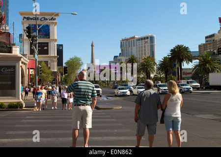 Fußgänger, die unter dem Schild zum Hotel in Monte Carlo und Kasino auf dem Las Vegas Boulevard (dem Strip) spazieren Stockfoto