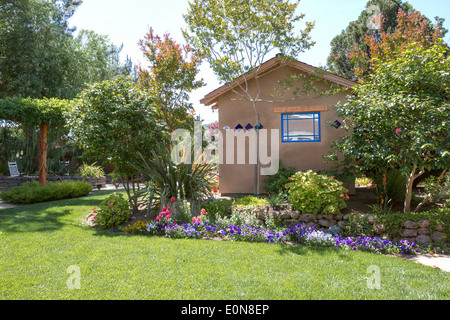 Südwestliche Art Schuppen in einem schönen begrünten Hinterhof-Garten mit Blumen und üppiger Vegetation Stockfoto