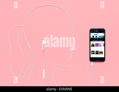 Frau Kopf Gliederung durch ein Kopfhörer-Kabel eingesteckt in iPhone 5 s Smartphone mit iTunes Music Store auf dem Display gemacht. Stockfoto