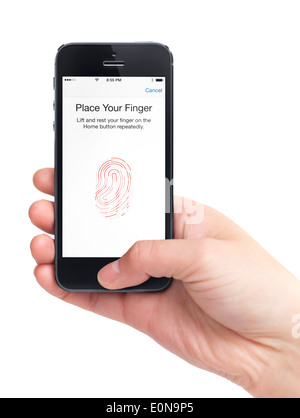 Nahaufnahme von einer Hand, die iPhone 5 mit einem Daumen gescannt mit einem Fingerabdrucksensor. Tippen Sie auf ID-Security-Konzept. isoliert Stockfoto