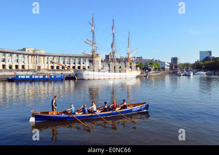 Bristol, UK. 17. Mai 2014. Am frühen Morgen Ruderer gesehen vorbei ein Großsegler im Hintergrund auf den schwimmenden Hafen in der Stadt Bristol in Großbritannien gesehen, wie die Sonne, um einen wunderbaren Tag im Voraus aufgeht. Meteorologen prognostizieren warmes und sonniges Wetter für das Wochenende. Bildnachweis: Robert Timoney/Alamy Live-Nachrichten Stockfoto