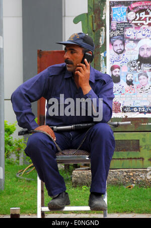 (140517)--ISLAMABAD, 17. Mai 2014 (Xinhua)--A privater Wachmann Gespräche über sein Handy über Welt Telekommunikation und Gesellschaft-Infotag in Islamabad, der Hauptstadt von Pakistan am 17. Mai 2014. Welt-Telekommunikation und Gesellschaft-Info-Tag soll zum Gedenken an die Gründung der International Telecommunication Union am 17. Mai 1865, und markieren Sie ihre Rolle in der Welt zu verbinden. (Xinhua/Saadia Seher) Stockfoto