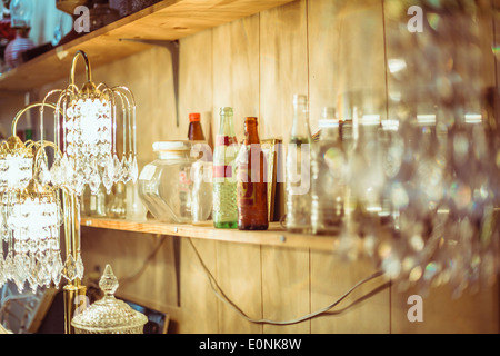 unübersichtlich Regal mit Flaschen und Behälter in Vintage-shop Stockfoto