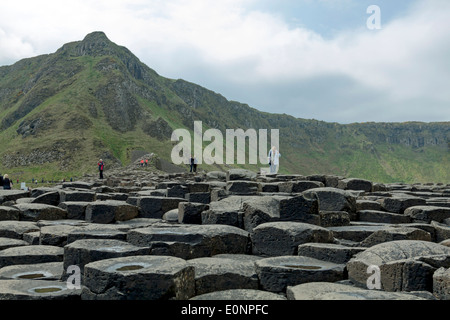 Touristen erkunden den Giant's Causeway, County Antrim, Nordirland, Vereinigtes Königreich, einem berühmten UNESCO-Weltkulturerbe. Stockfoto