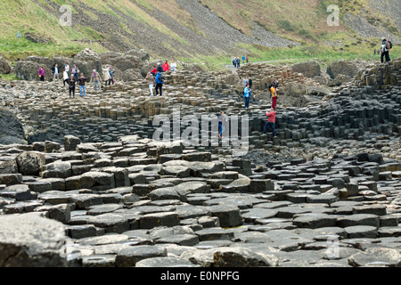 Touristen erkunden den Giant's Causeway, County Antrim, Nordirland, Vereinigtes Königreich, einem berühmten UNESCO-Weltkulturerbe. Stockfoto