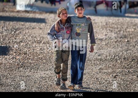 Zaatari Camp, Al Mafraq, Jordanien. 8. Februar 2014. Die Flüchtlinge von Zaatari - gehen zwei jungen gemeinsam am östlichen Rand des Lagers. Kinder unter 18 Jahren entfällt die Hälfte der Lager 110.000 Einwohner. In der jordanischen Wüste liegt 10 Kilometer von der syrischen Grenze ein Flüchtlingslager Zaatari genannt. Es ist Heimat von mehr als 110.000 Vertriebene, die den Krieg in Syrien seit Juli 2012 geflohen sind. Die meisten dieser Flüchtlinge sind aus der südlichen Region von Daraa, wo die Kämpfe zu den schlechtesten im syrischen Bürgerkrieg gesehen worden, die mehr als drei Jahre lang gezogen hat, auf. Die kostenlose Syr Stockfoto