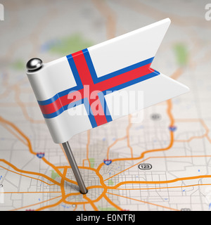 Kleine Flagge der Färöer Inseln auf einem Kartenhintergrund mit selektiven Fokus. Stockfoto