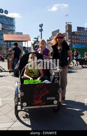 Kopenhagen, Dänemark – 17. Mai 2014: "Dies ist die Art, wie wir als Familie hier in der Innenstadt bewegen, weil es leicht und sicher ist", sagt Ziga (links), Mutter Rebecca 5 Jahre (Mitte) und Casper, 9 Jahre (links) über hier 3 Christiania Bike Rad. Zusammen mit vielen anderen Enthusiasten für dieses spezielle Bike feierten sie das 30 Jahre Jubiläum der freien Stadt Christiania ikonischen Cargobike, das im Jahr 2011 Danish Design Center von seiner Majestät ausgezeichnet, dänische Kronprinz Frederik. Stockfoto