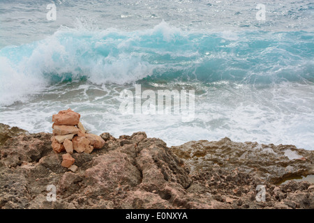 Türkis Wave spritzt auf wenig Stein Turm und Ufer am Cap de Ses Salines, South Mallorca im Oktober. Mallorca, Spanien. Stockfoto