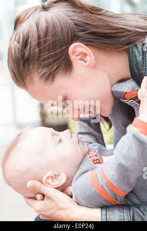 Junge Mutter mit ihrem Sohn im zeitigen Frühjahr spielen. Stockfoto