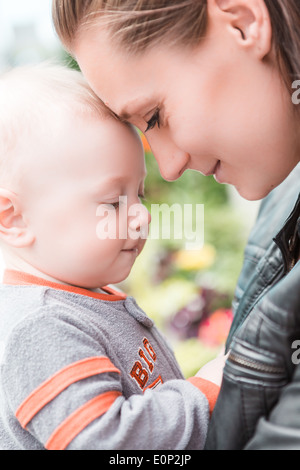 Junge Mutter mit ihrem Sohn im zeitigen Frühjahr spielen. Stockfoto