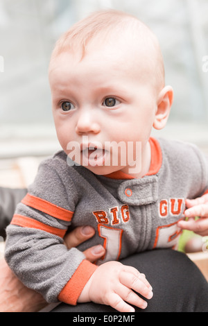 Niedliche Baby Boy Spielen auf der Bank in einem Park. Stockfoto