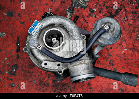 Alte, verschlissene Turbolader Turbo-Dieselmotor auf rotem Grund Stockfoto